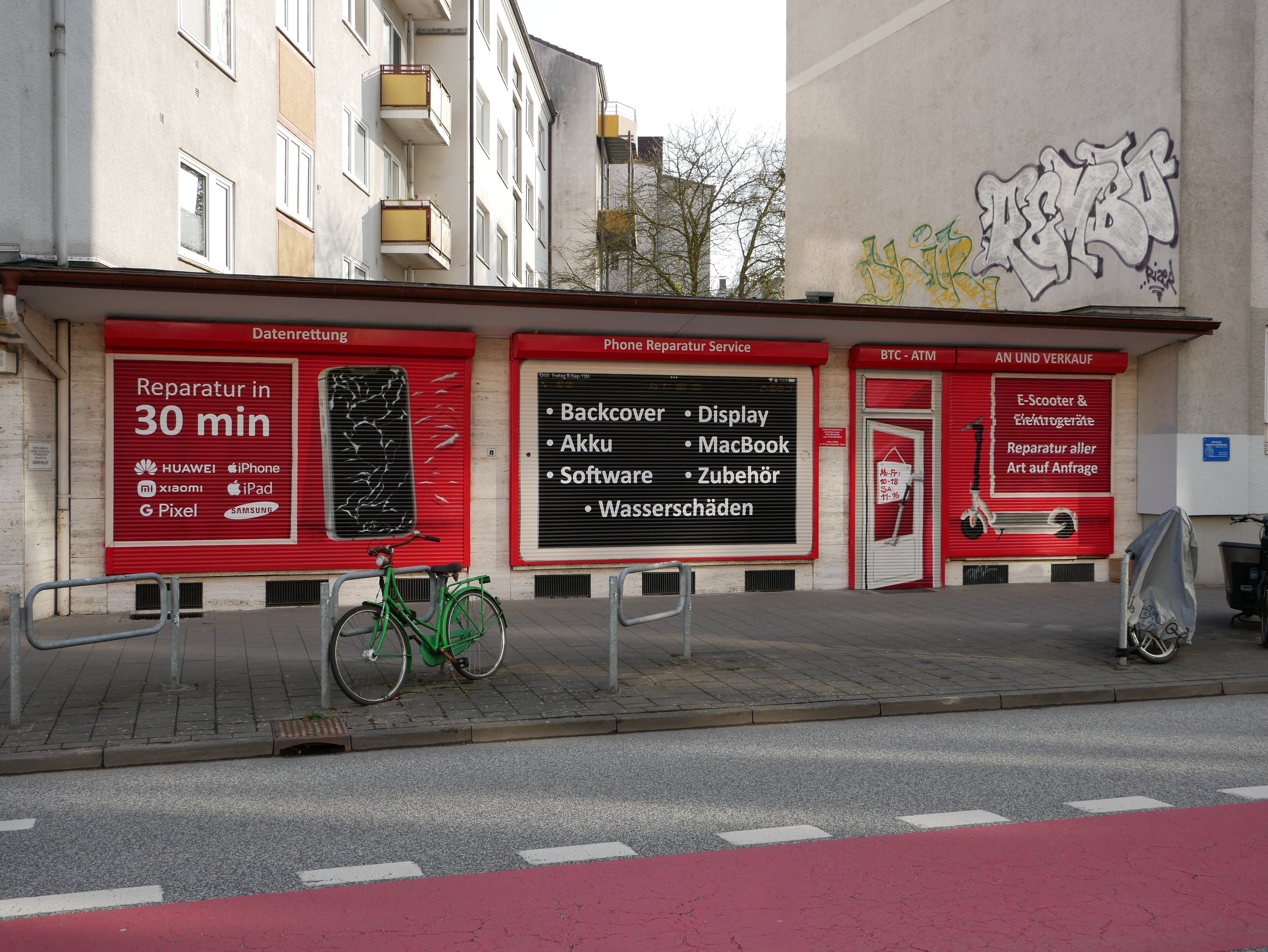 Bemalte Rollläden eines Handy-Reparaturgeschäfts in Kiel mit auffälligen Graffiti